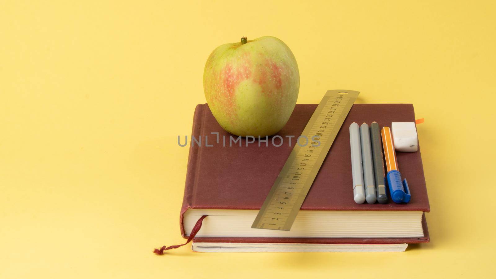 Work desk of a student, a schoolboy - educational supplies on a yellow background, a place for text. High quality photo