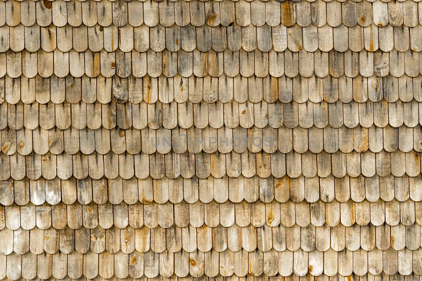 textured background of wooden tiles on the roof of an old house. natural material, wooden roof. close-up