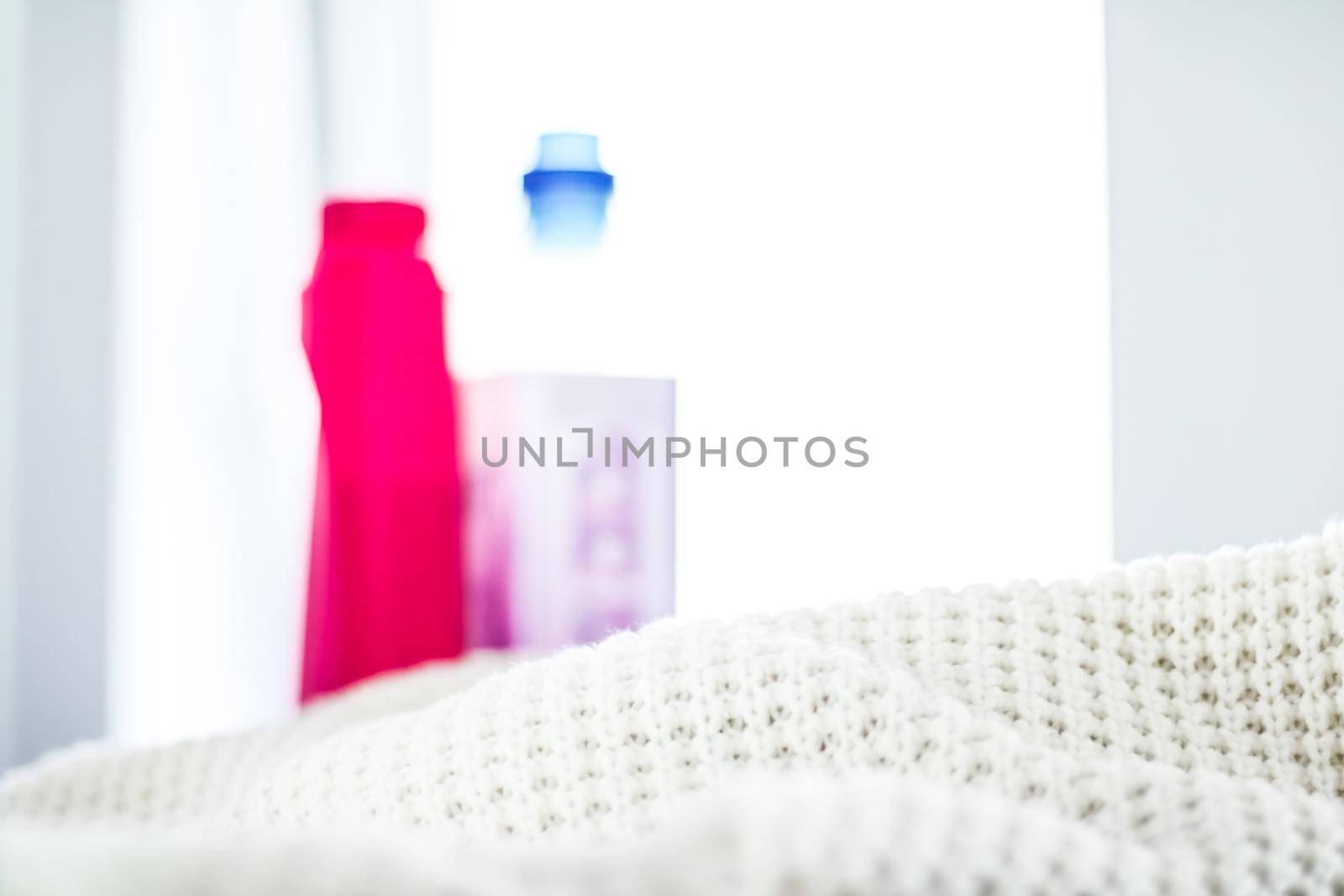 Housekeeping, fabric textures and handmade knitwear concept - Warm knitted clothes and liquid laundry detergent