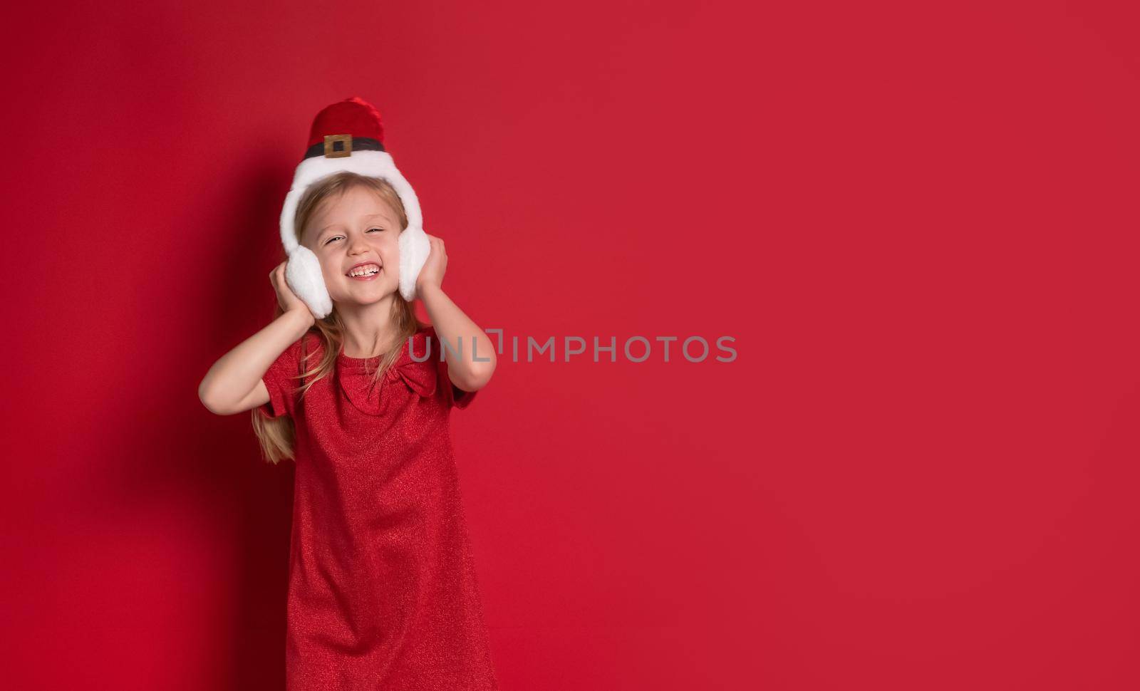 Long banner. girl in christmas clothes, surprise and laugh on a red background by Ramanouskaya