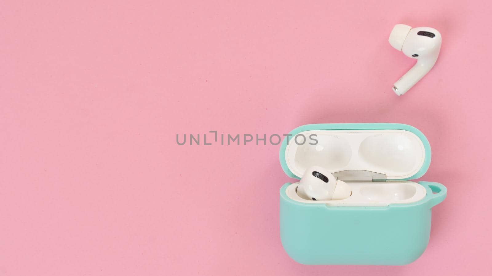 Wireless headphones and pink background case, text space. High quality photo