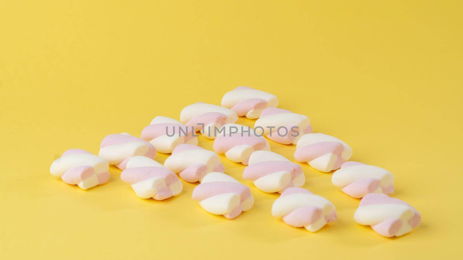 Marshmallows on a yellow background in the form of a triangle by voktybre