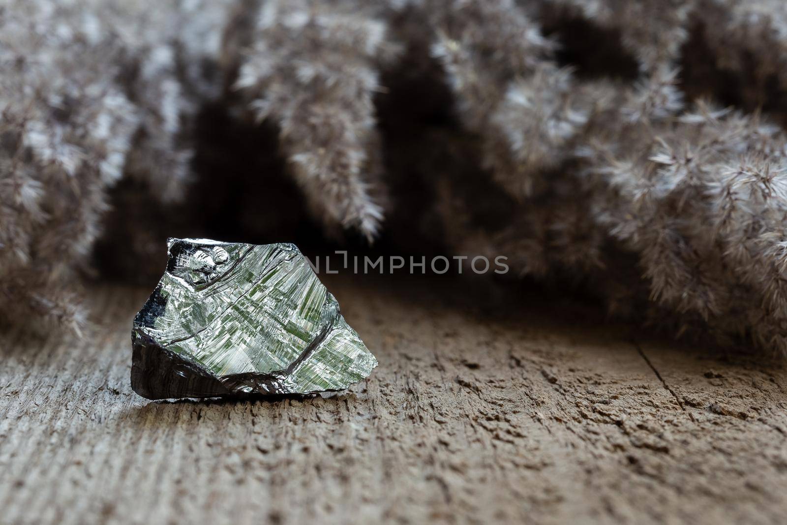 Piece of raw polycrystalline silicon, polysilicon, over wooden background