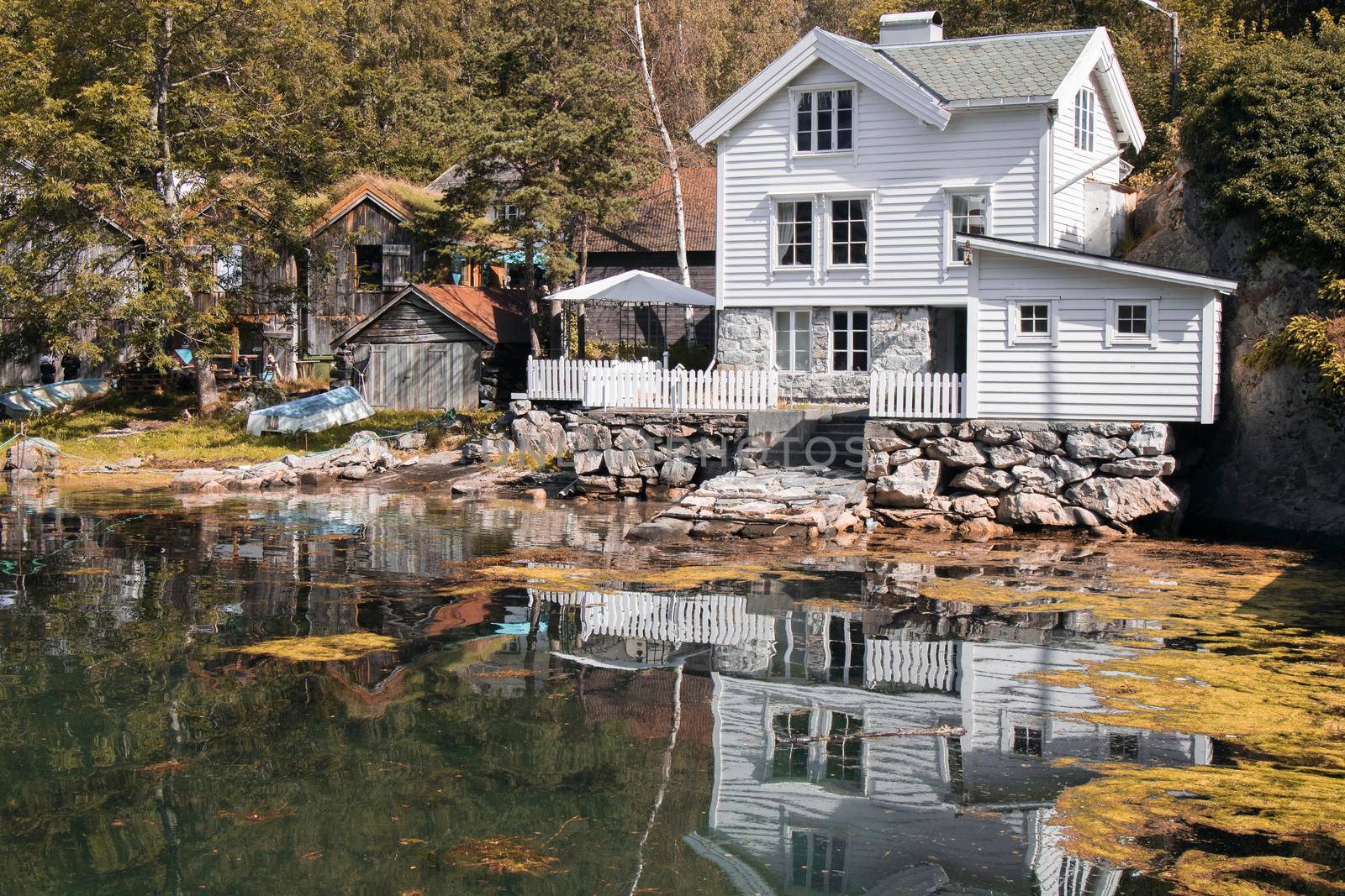 Beautiful white house and its reflection on the river in Norway