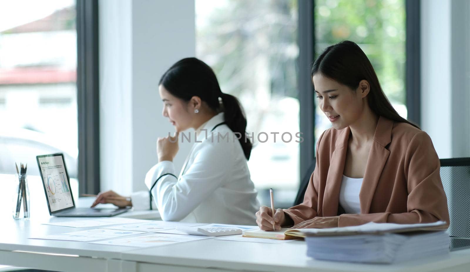 Asian businesswoman working in the office with working documents. by wichayada