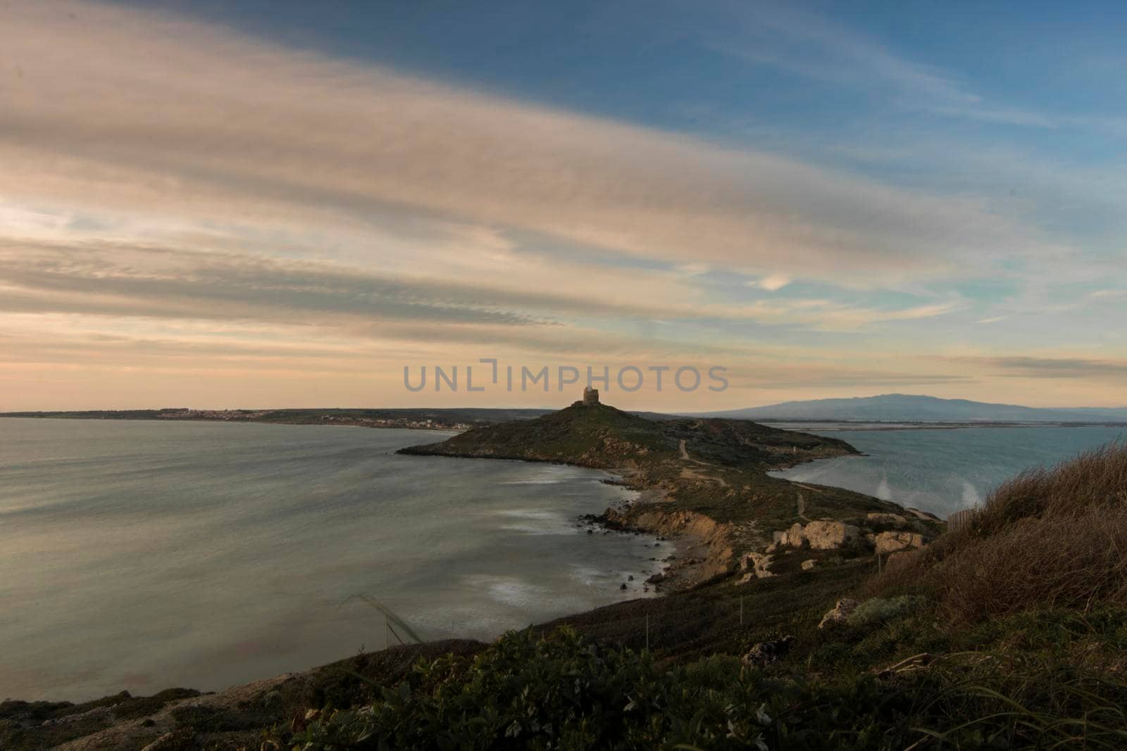 Landscape showing Cape San Marco among water in Sardegna island in Italy in a long exposure picture