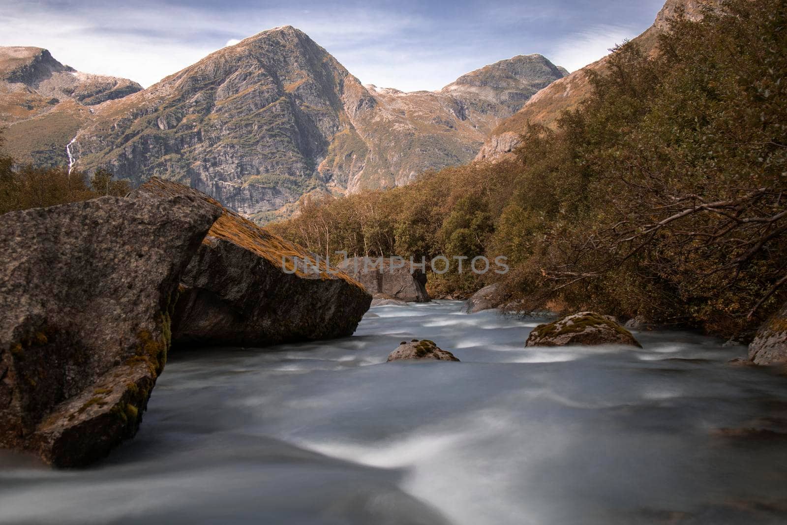 A river in a wild environment and some peaks on the way to Briksdal glacier in Norway