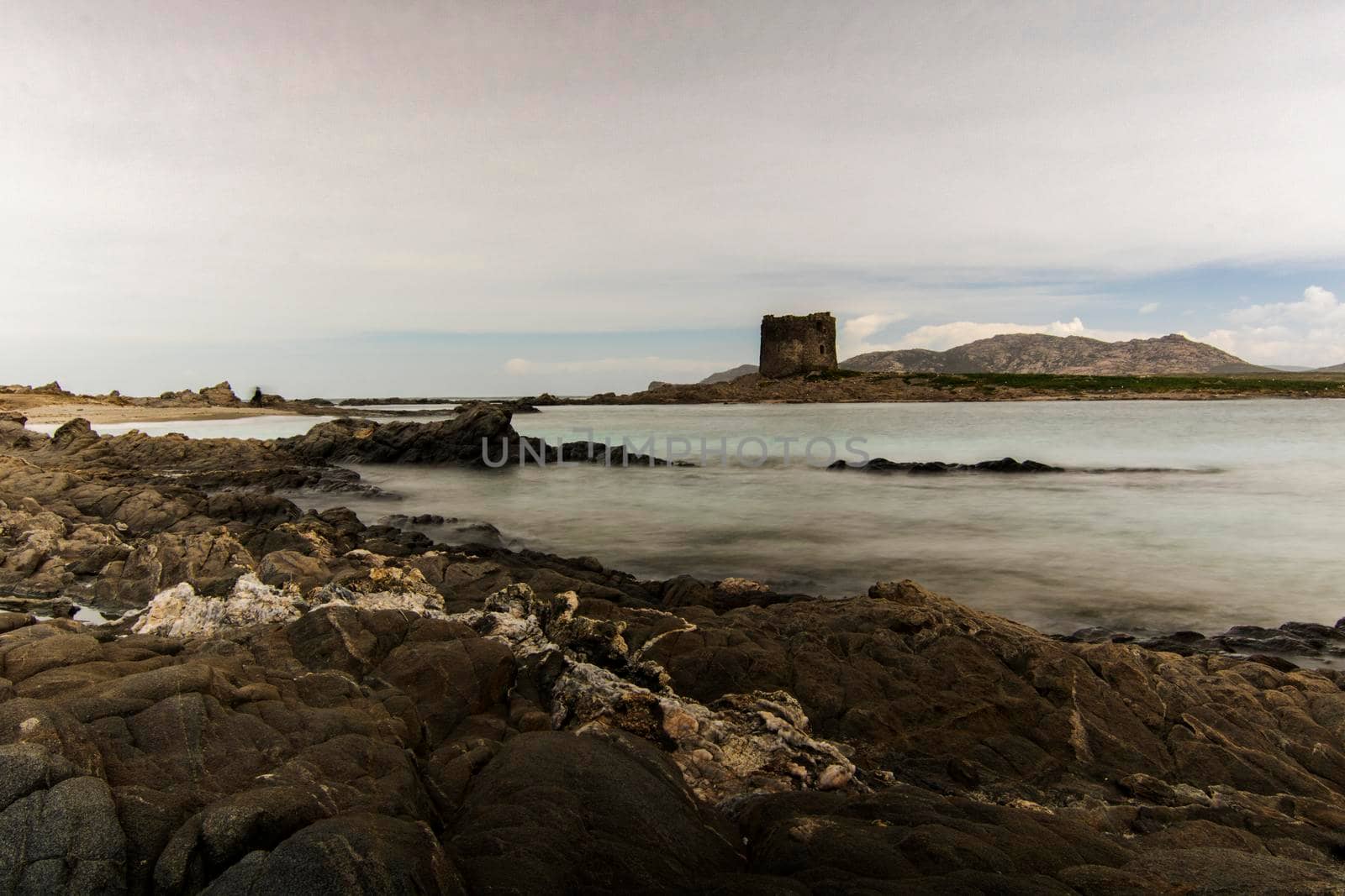 La Pelosa beautiful and tourist rocky beach and tower in Sardegna island in Italy in a long exposure picture