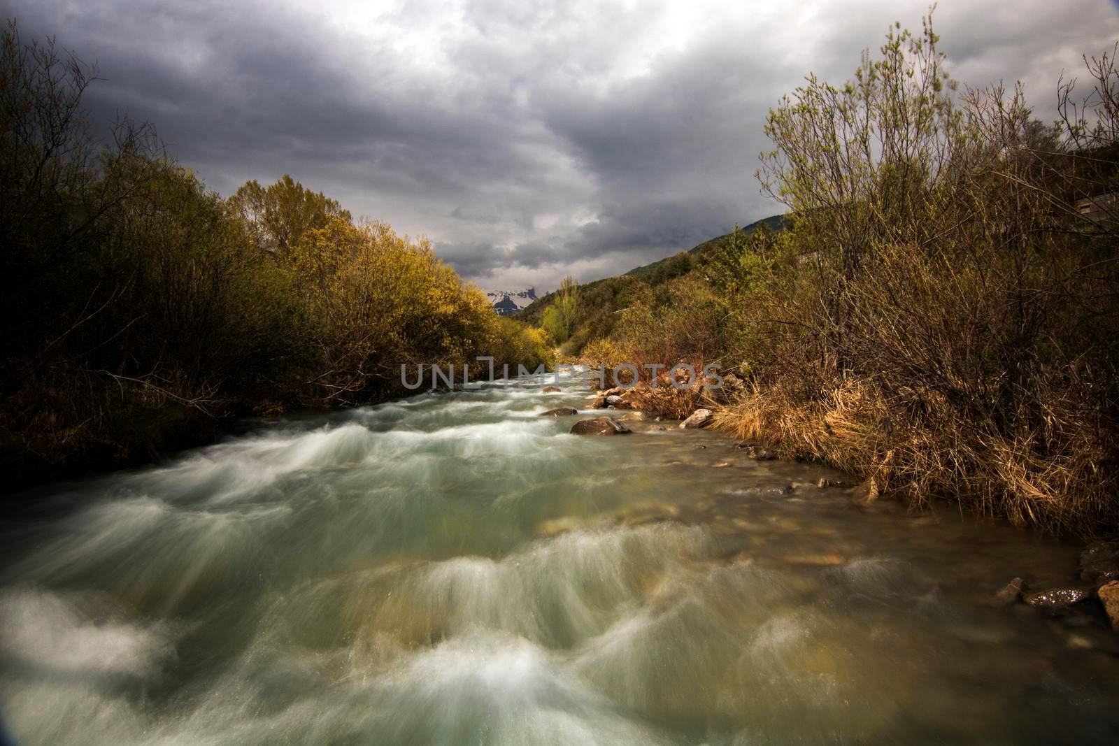 Wild river under a cloudy sky in long exposure picture in Spanish Pyrenees