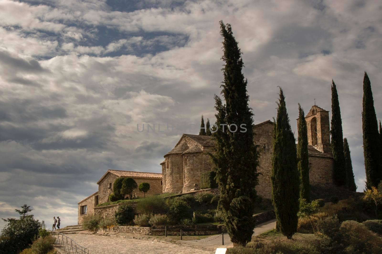 Romanesque church called Santa Maria de La Tossa and some trees under a cloudy sky