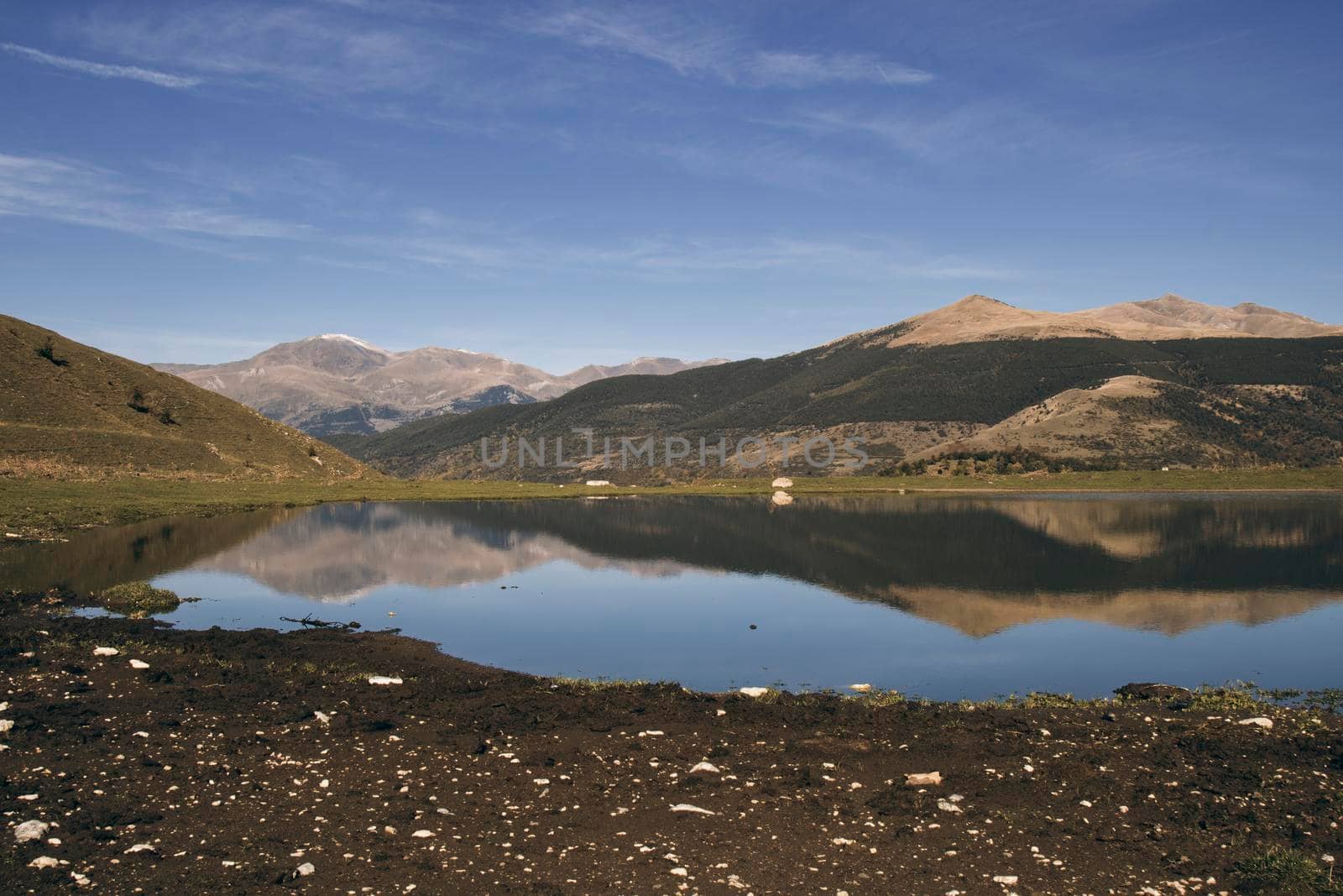 Landscape showing some mountains and its reflection on a lake with a blue sky