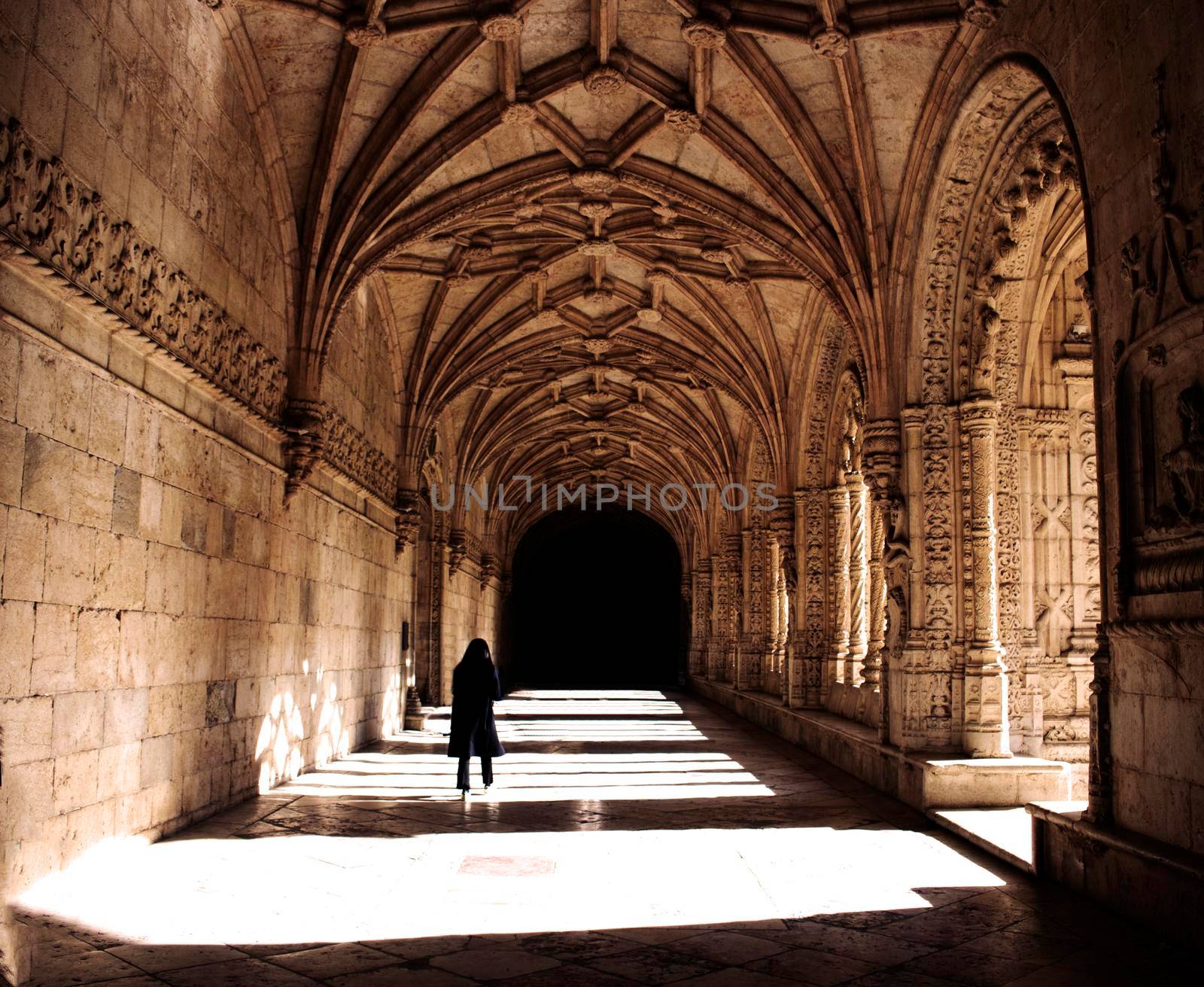 A girl walking in a cloister in Jeronimos Monastery in Lisbon