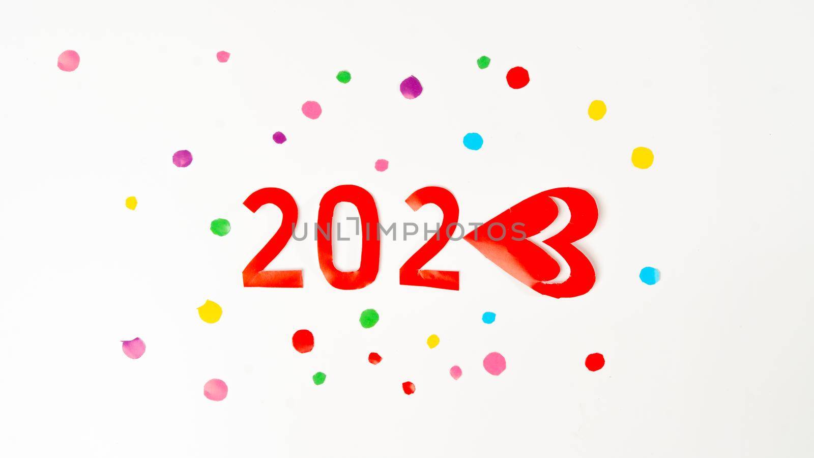 The number 2023 in red in multi-colored confetti, new year with love by voktybre