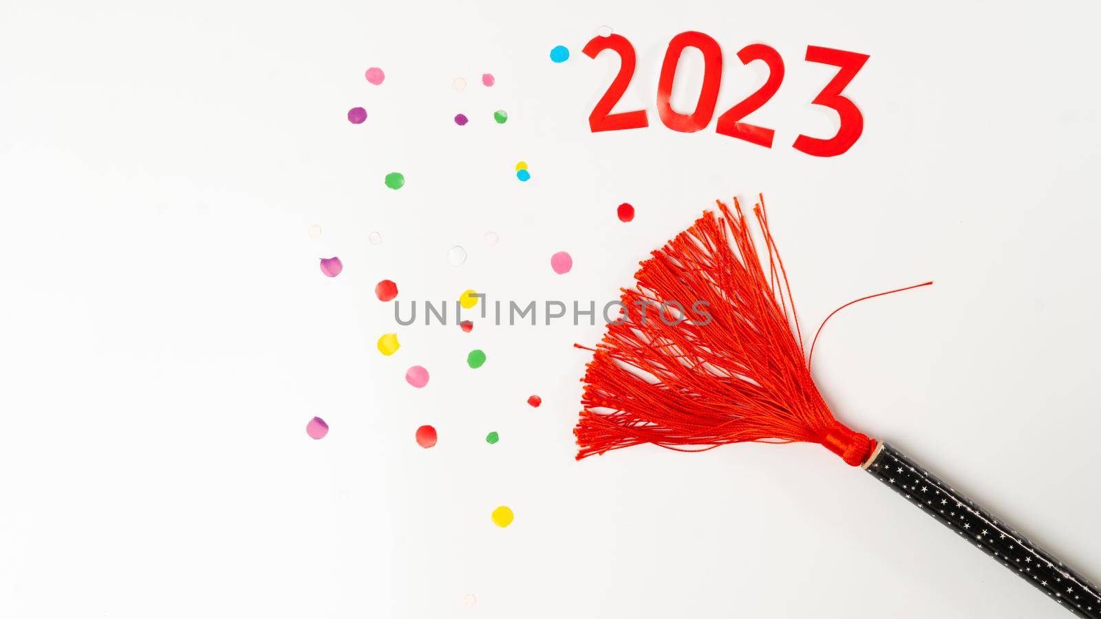 clapperboard with red tassel and confetti and the number 2023 on a white background, new year by voktybre