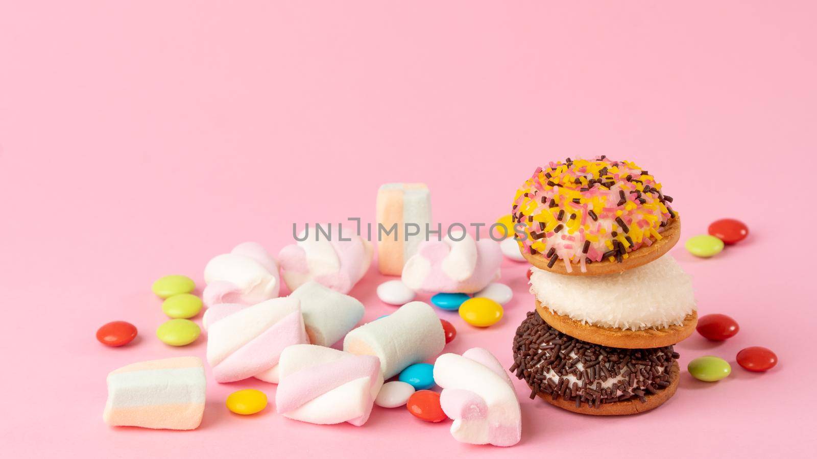 Sweets - cake, sweets, dragees, marshmallows on a pink background. High quality photo