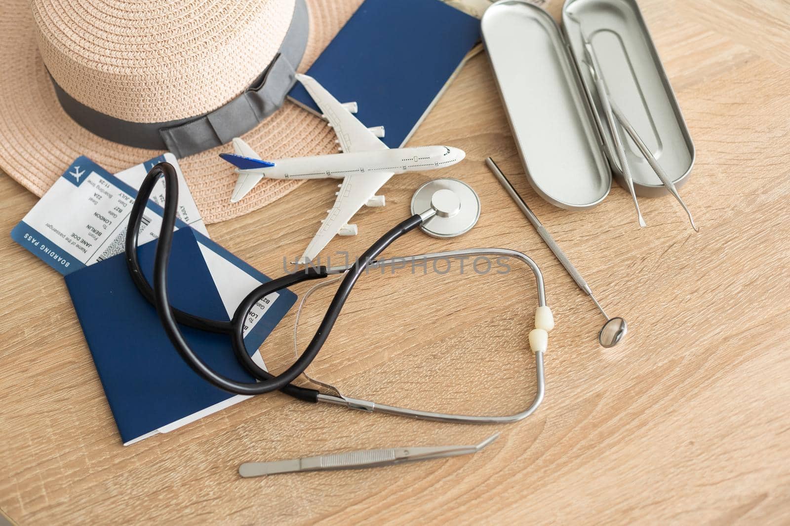 Medical tourism concept. Stethoscope with passport and tickets, toy plane.