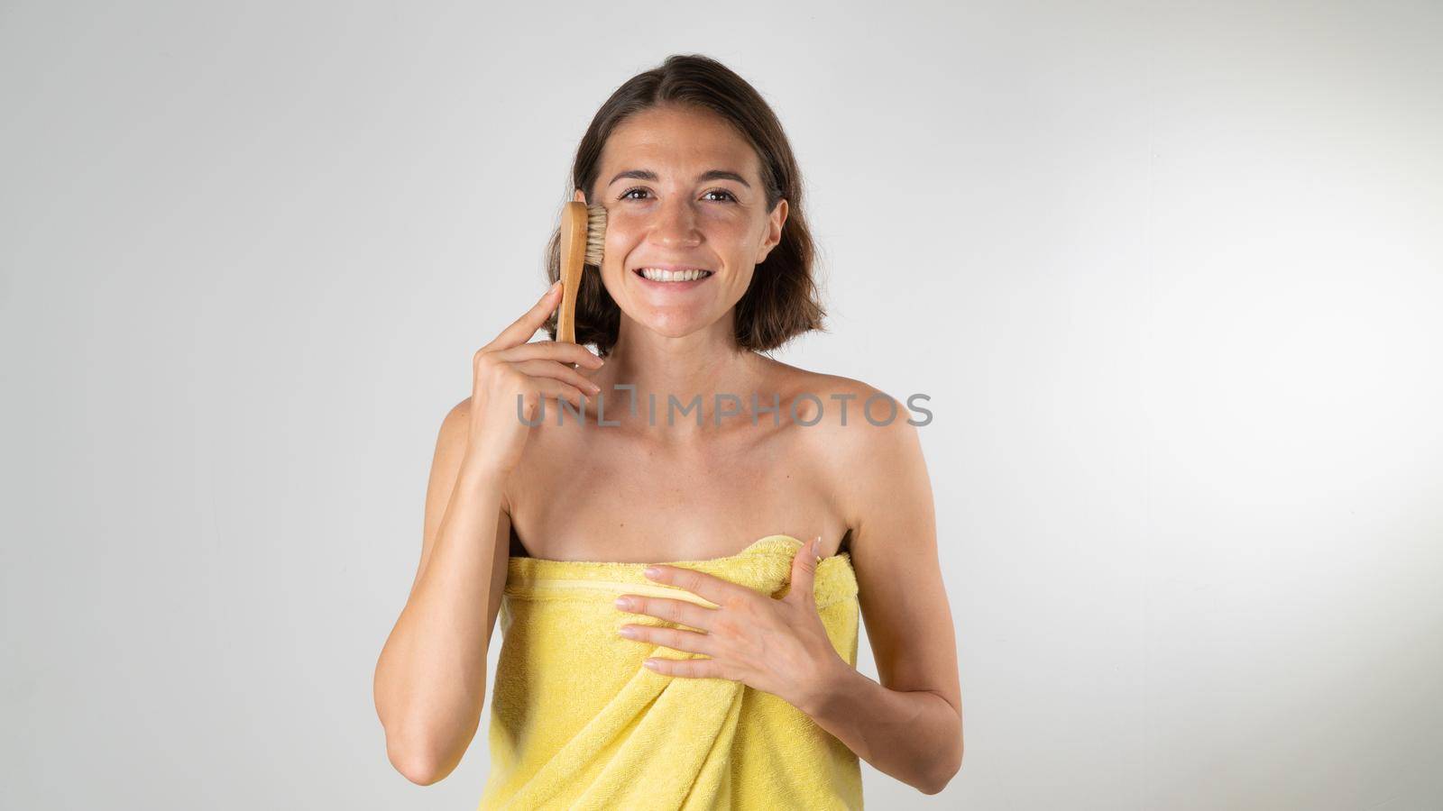 Woman with massage brush does face lift at home after shower. High quality photo