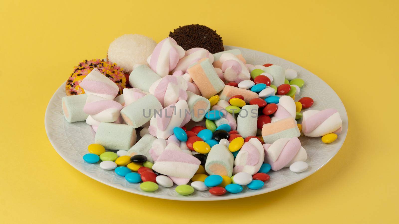 Plate with sweets on a yellow background by voktybre