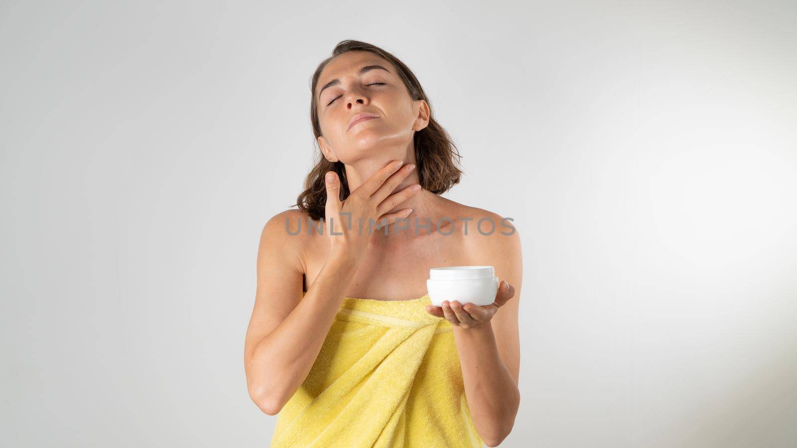 A woman applies cream to the neck - home care. High quality photo
