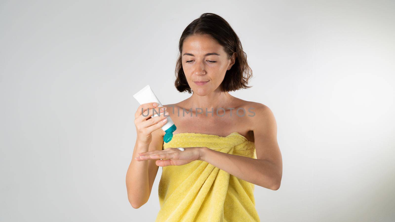 Woman squeezes hand cream out of tube - face and body care at home. High quality photo