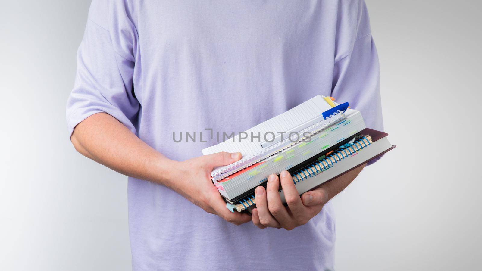 Men's hands hold a notebook, notebook, books and textbooks for classes. High quality photo