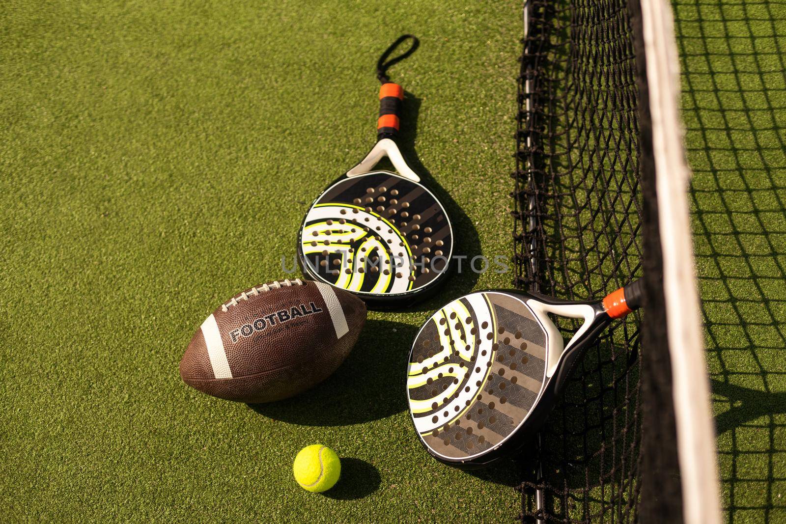 Set of sport equipment on floor, padel tennis, ball rugby.