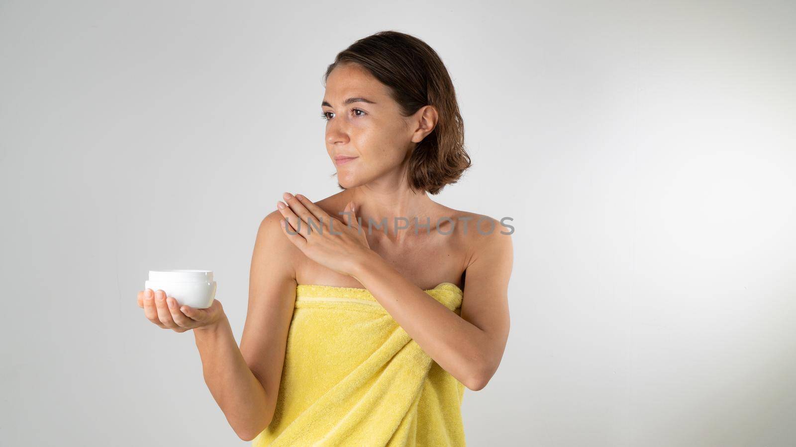 A woman smears the body with cream - home care for herself. High quality photo