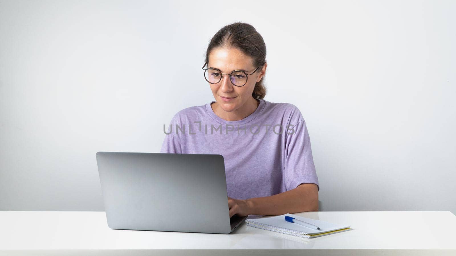 A girl typing at a laptop - remote education and work, online communication by voktybre