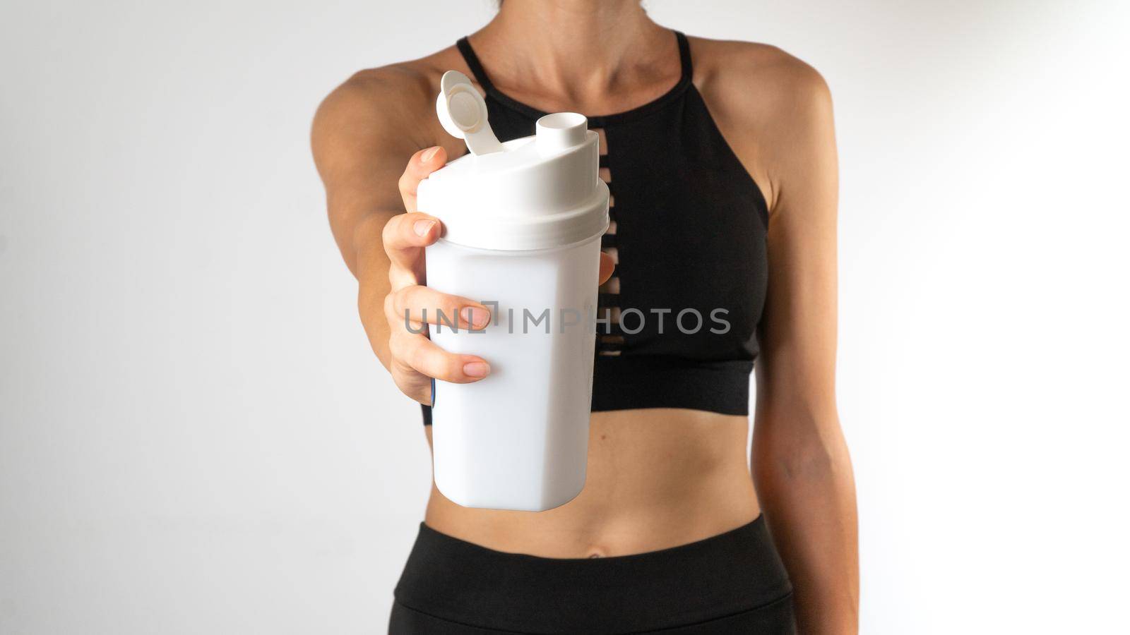 Women in sportswear keep shaker in the foreground - workout by voktybre