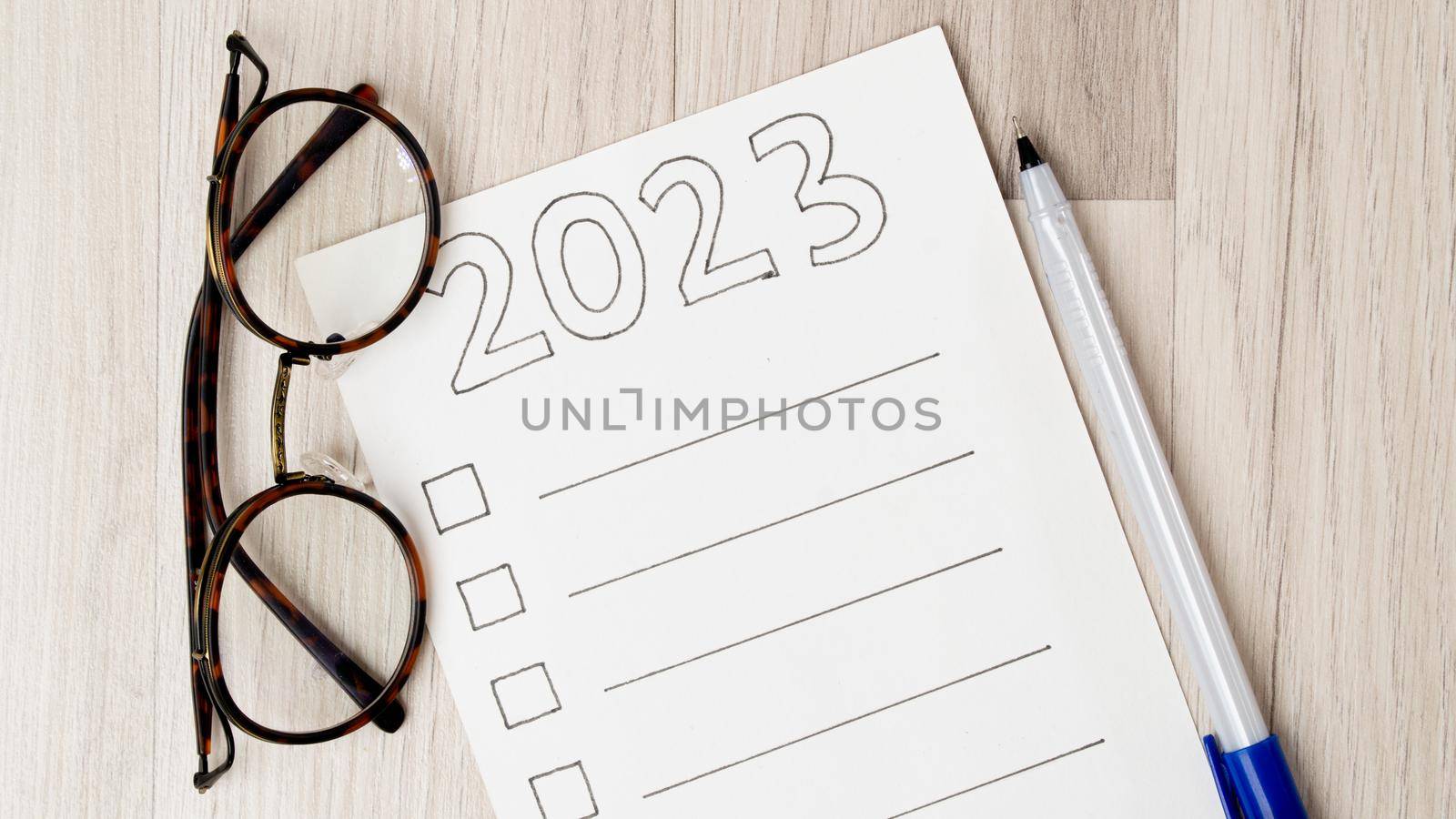 Checklist, glasses and pen on a wooden background by voktybre