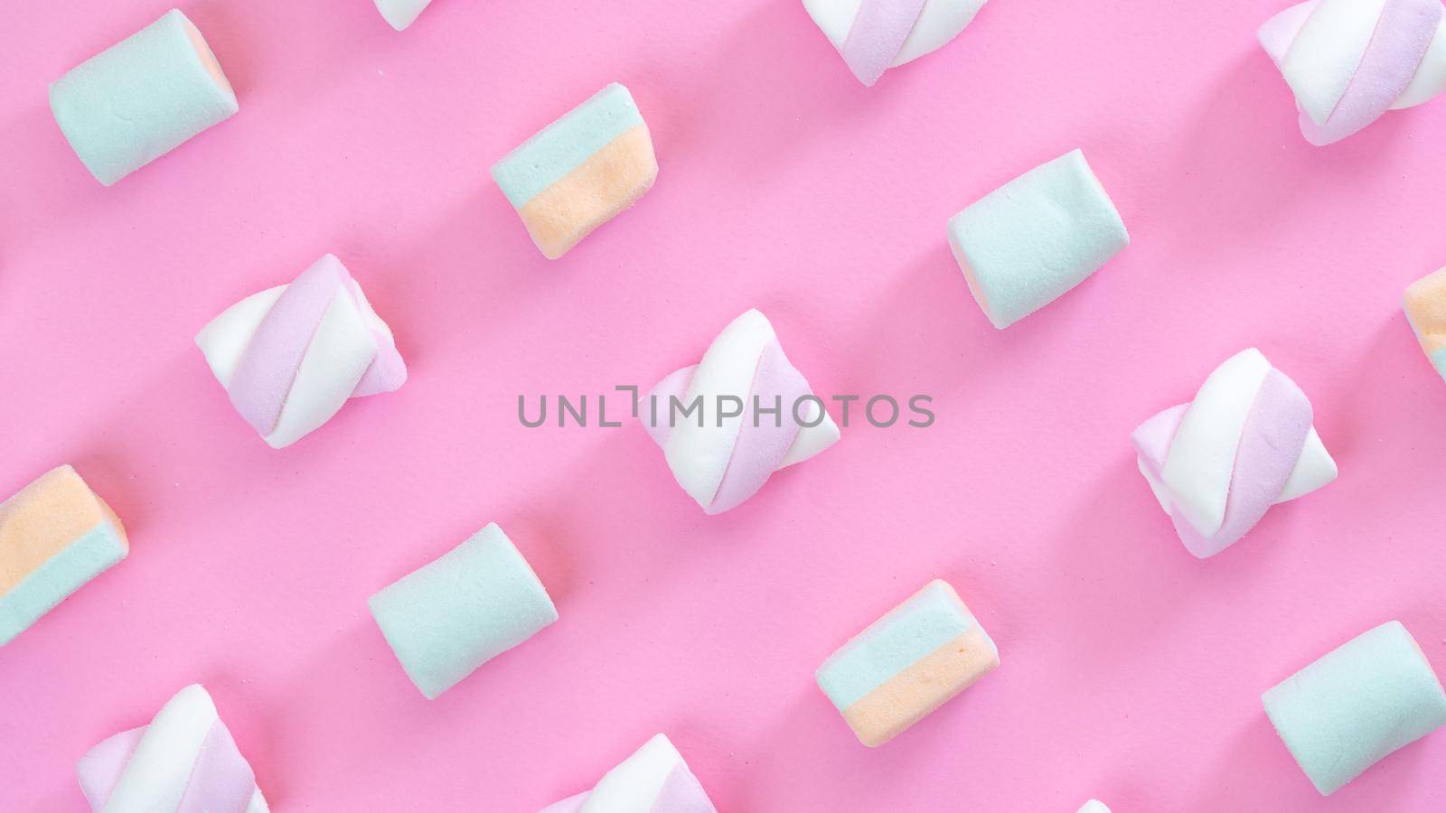 marshmallows on pink background diagonal lines close-up, multi-colored sweets. High quality photo