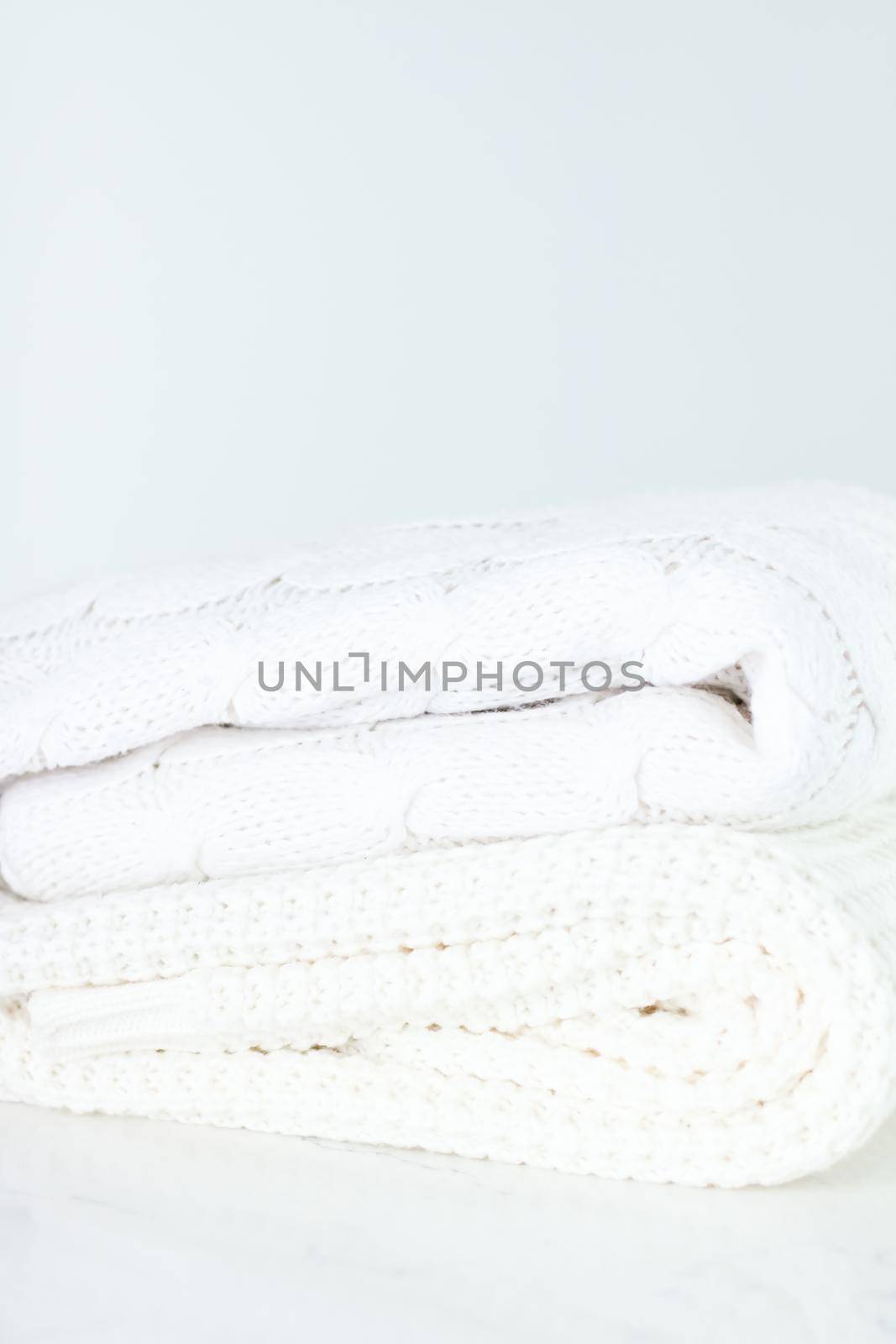 Knitwear, fabric textures and handmade items concept - Warm knitted clothes, soft and white