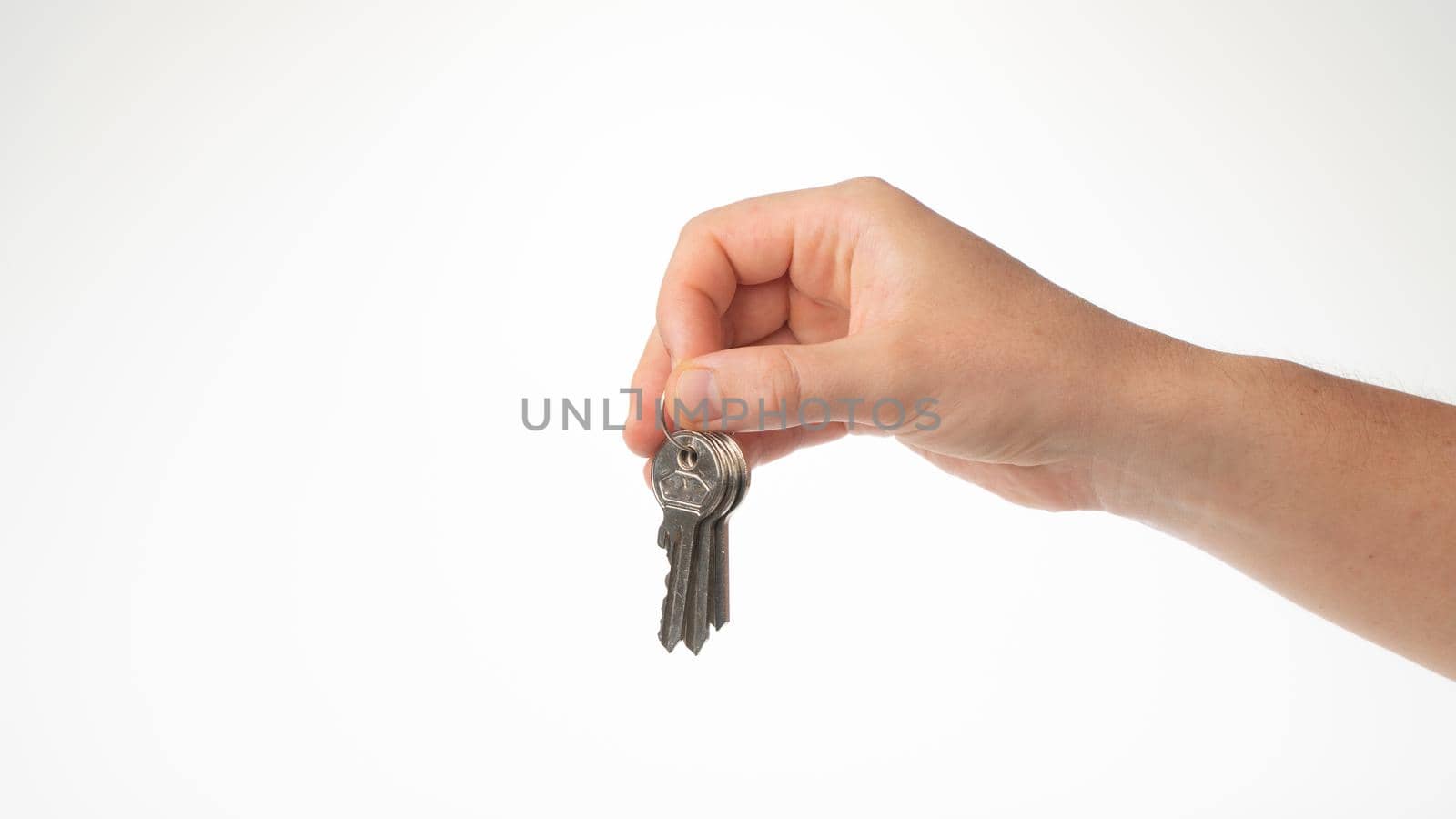 A man's hand holds a bunch of keys with his fingers by voktybre