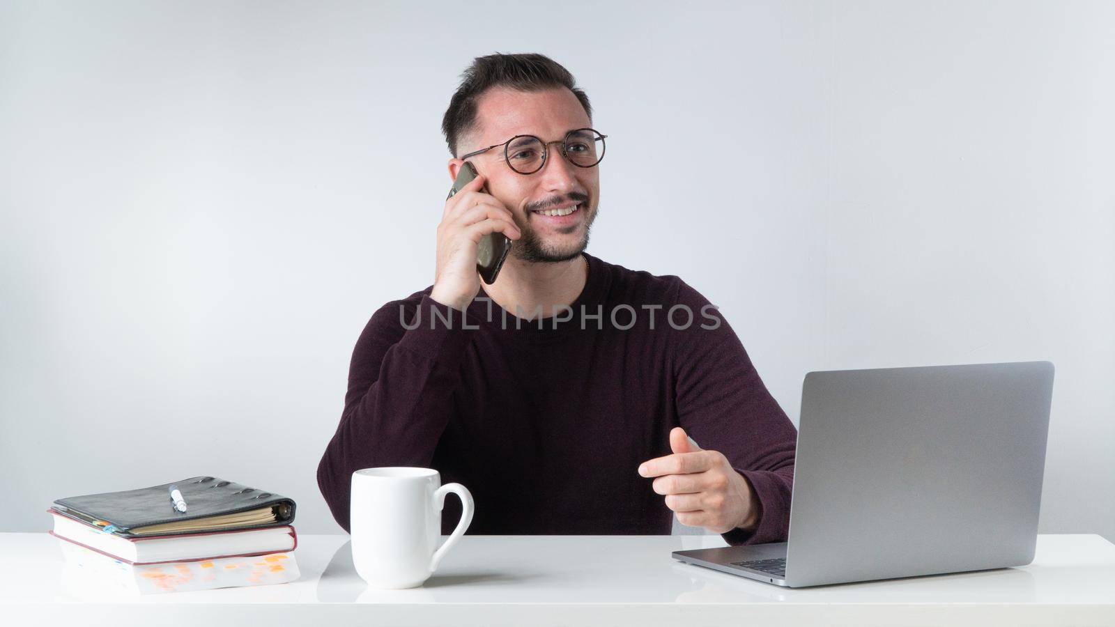 A man talks on the phone at a laptop, a desk in the office or at home. High quality photo