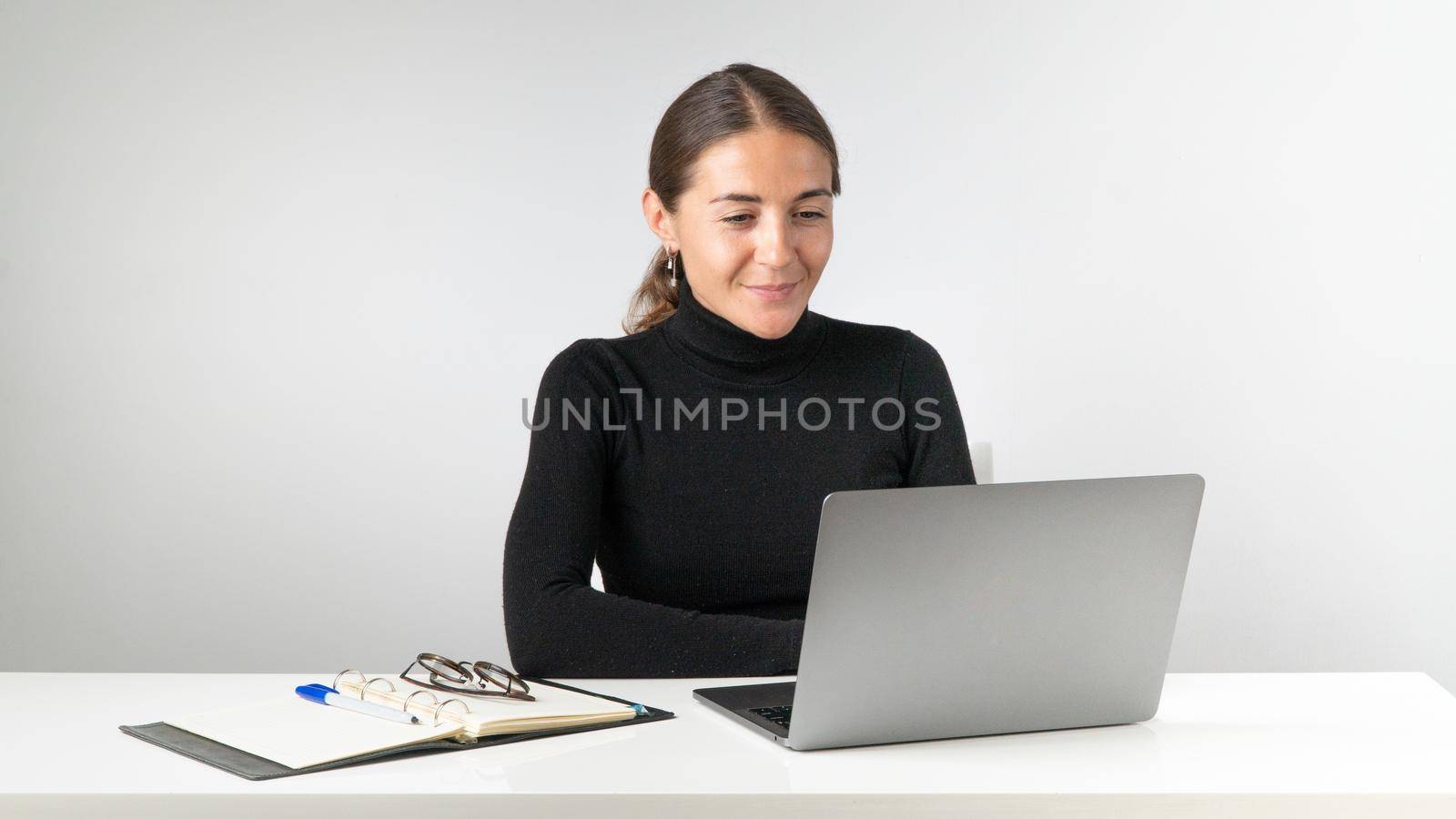 A woman works at a laptop on a white background by voktybre