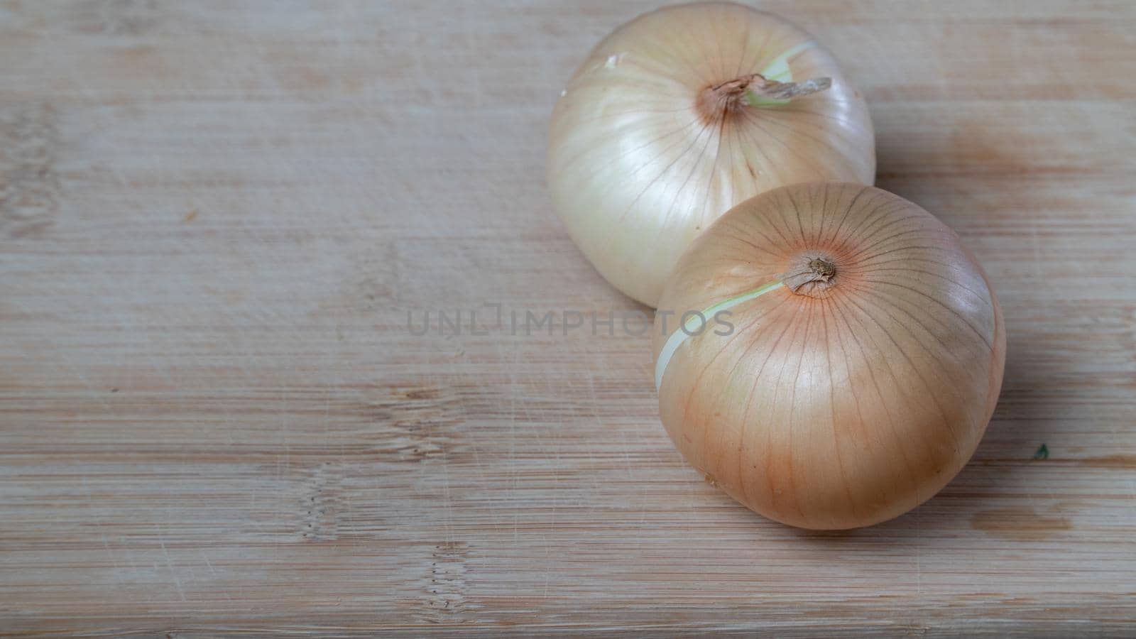 Onions in husks on a wooden board vegetables background by voktybre