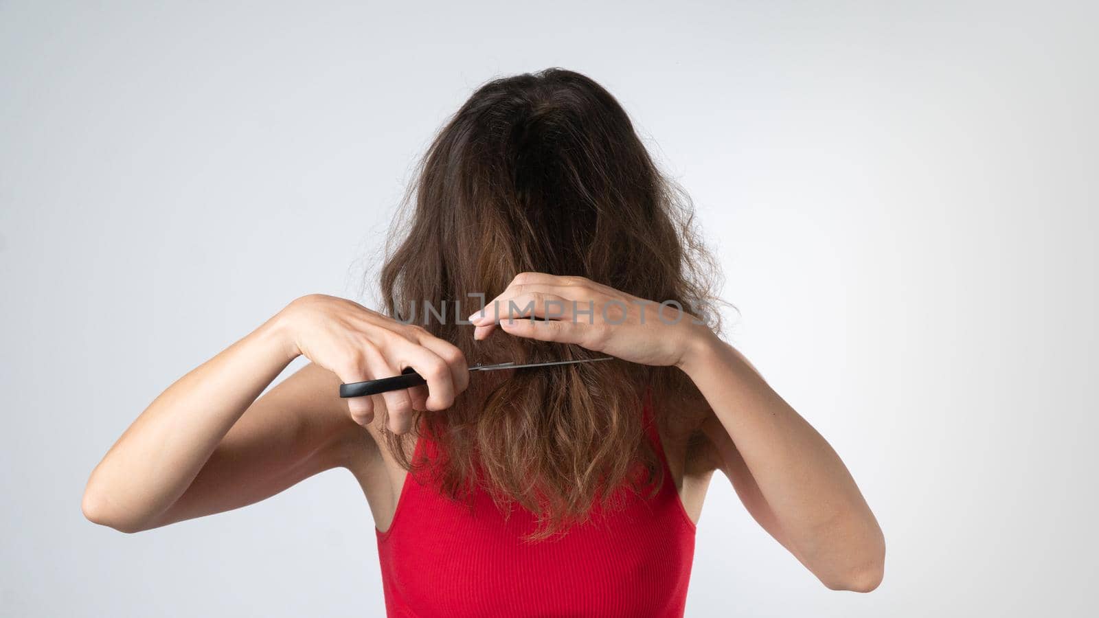 A woman with scissors cuts her own hair - weak and naughty, problematic hair,. High quality photo