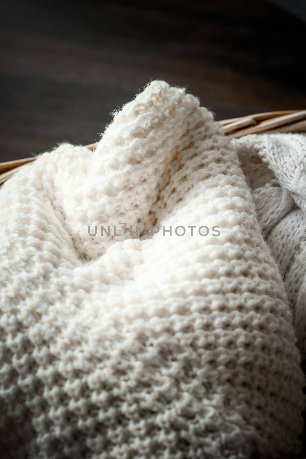 Knitted winter clothes in a basket by Anneleven