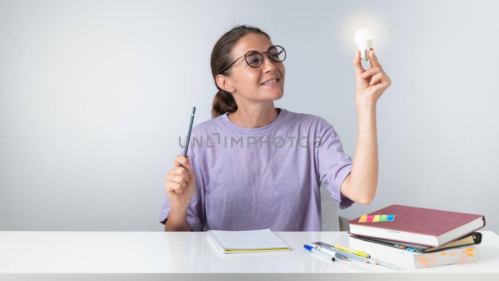 A girl is learning, a light bulb in her hand - an idea came by voktybre