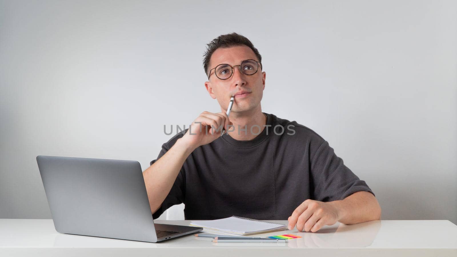 A student solves a problem - thinks at a desk with a laptop. High quality photo