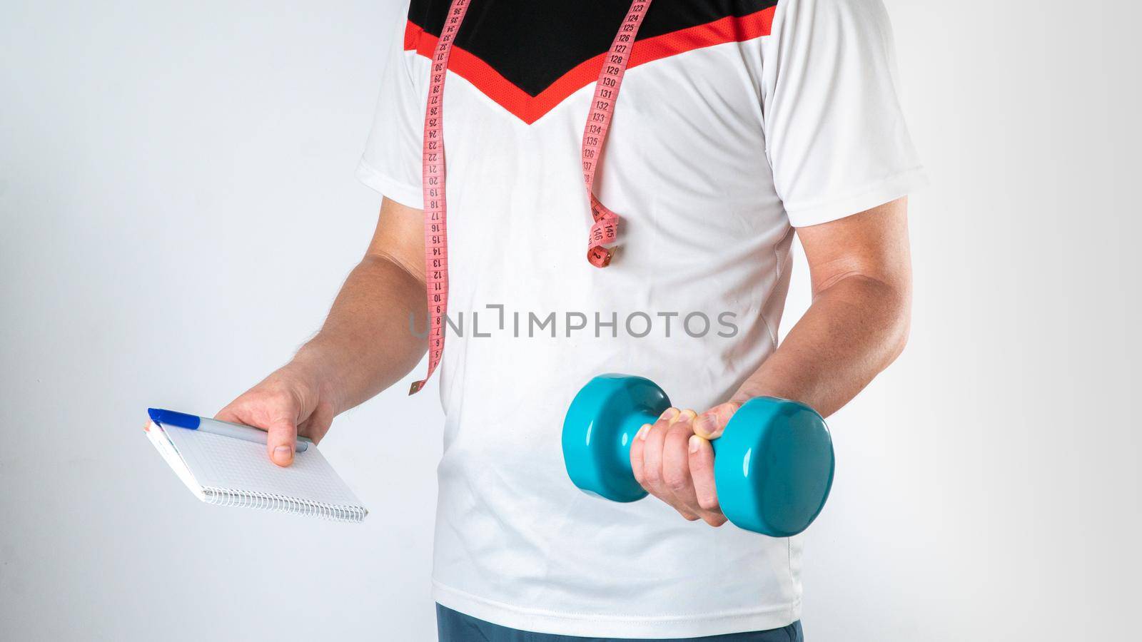 Trainer nutritionist man with dumbbell, notebook and measuring tape sports image by voktybre