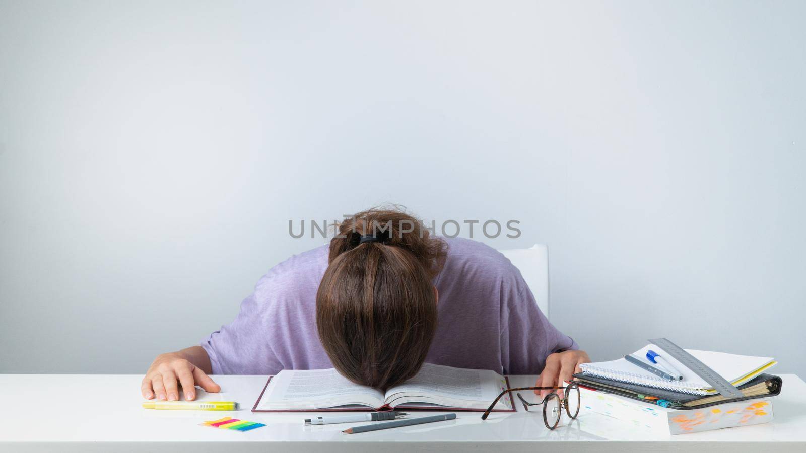 A student sleeps on a textbook - difficult study, heavy load. High quality photo