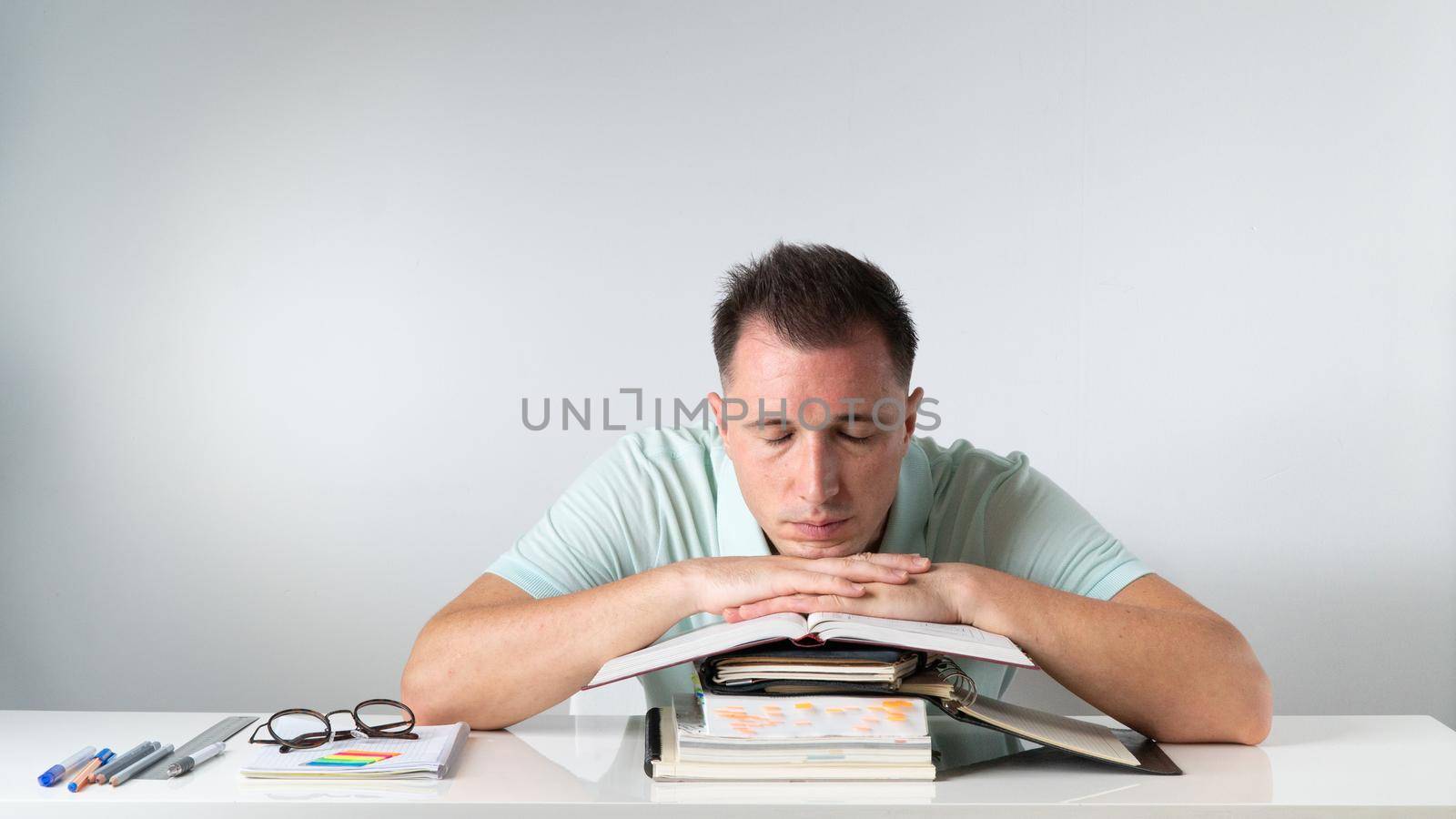 Student sleeps on books and notebooks - exams, studies, admission. High quality photo