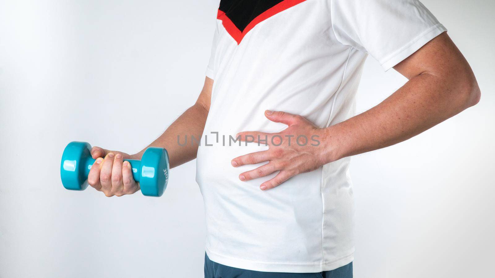 A man with a belly and a dumbbell begins to play sports, lose weight. High quality photo