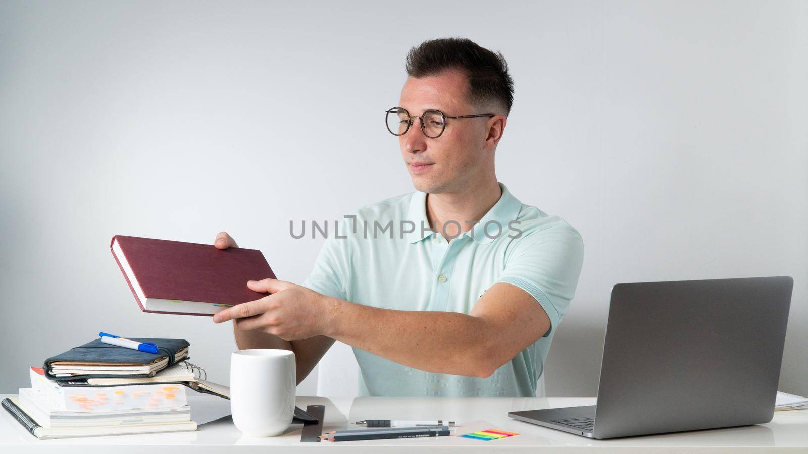 Student with a textbook at a table with teaching supplies. High quality photo