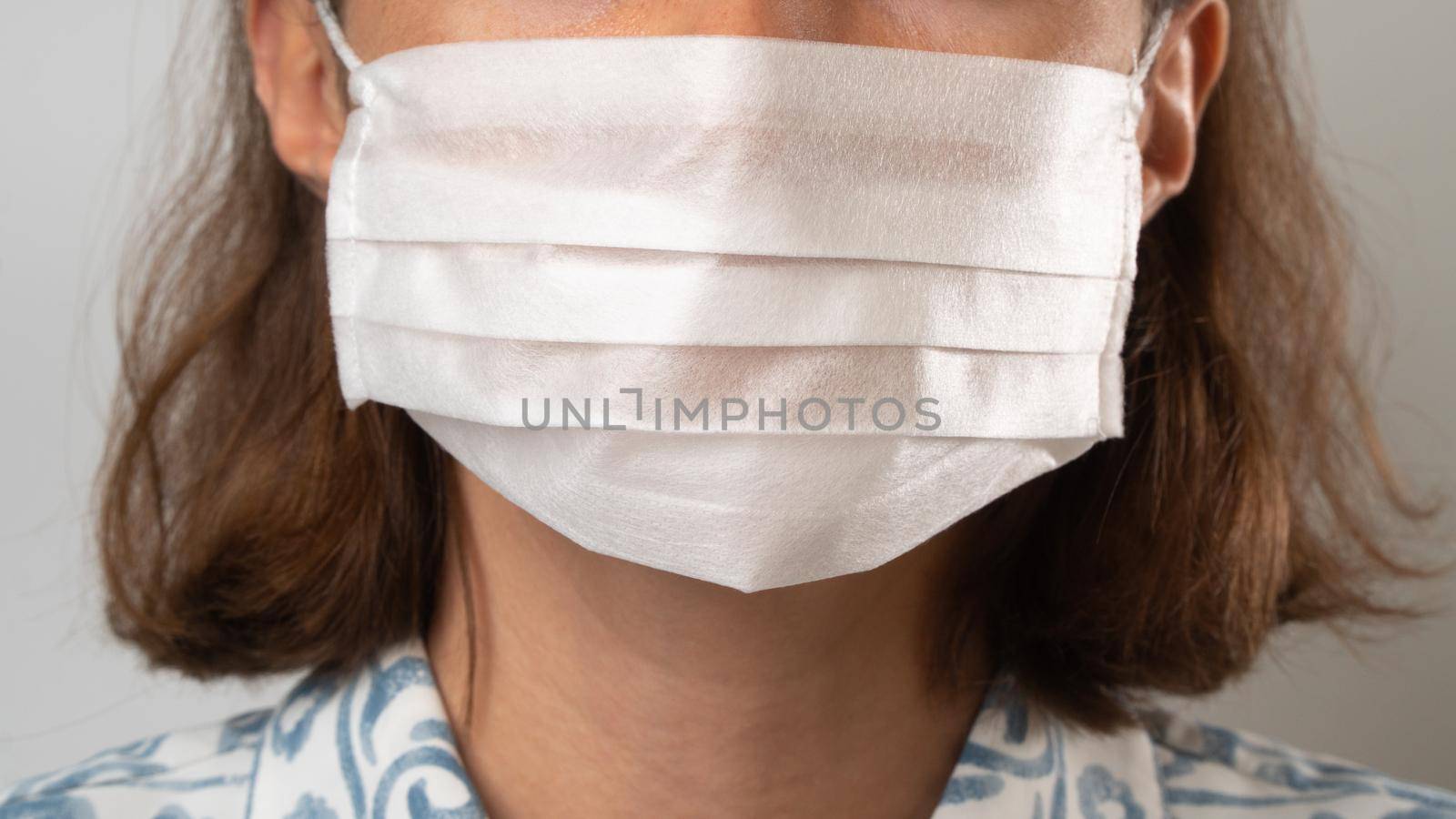 Close-up of a woman's lower face in a medical mask by voktybre