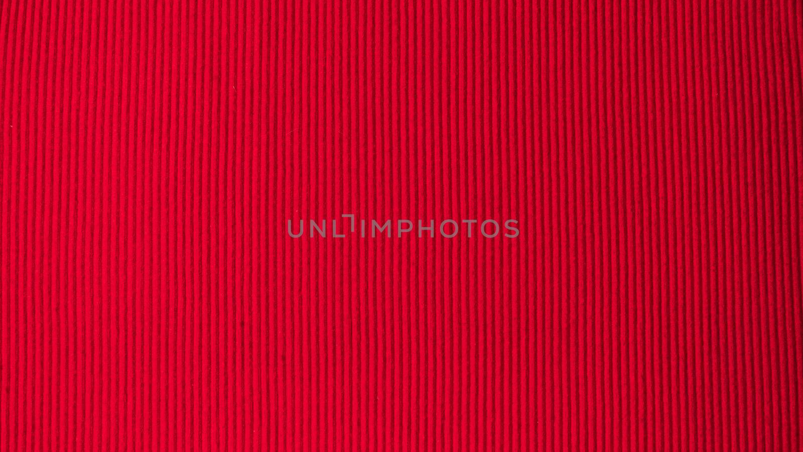 Bright red saturated background in volumetric strip fabric textile. High quality photo