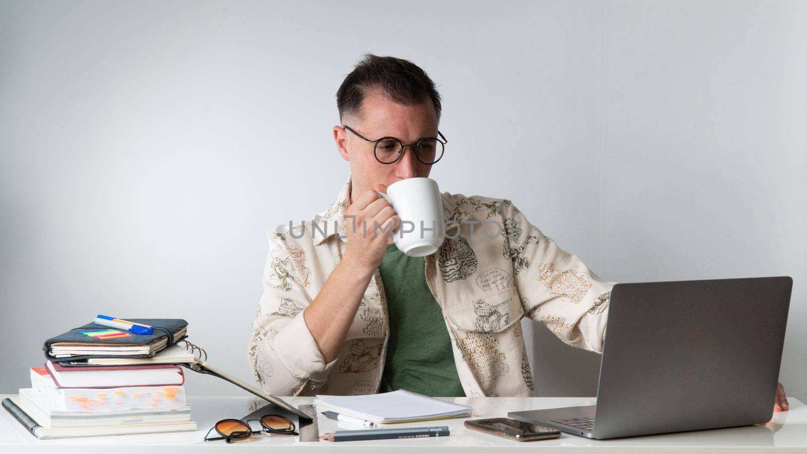 Student with a cup of coffee on his laptop - online education, freelancing. High quality photo