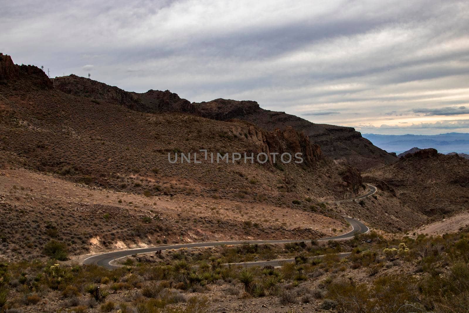 Curved road in a mountain under a cloudy sky in Arizona
