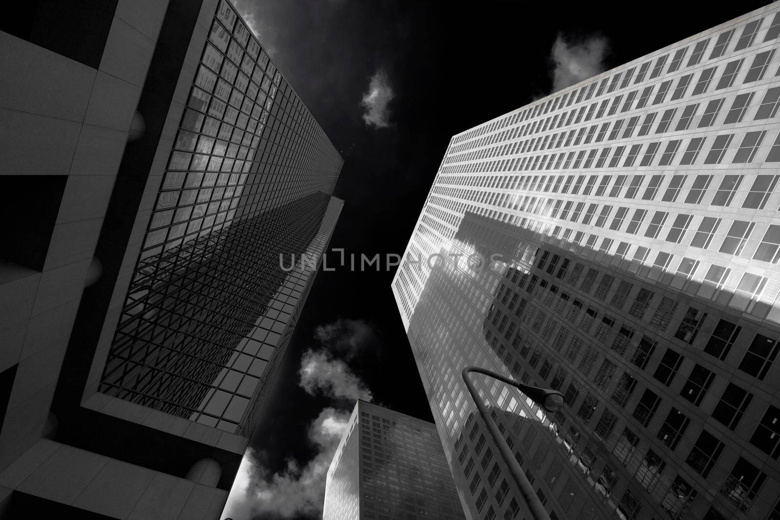 A couple of skyscrapers view from below with a dark sky in black and white in Los Angeles